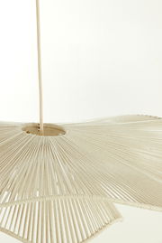 Nahaufnahme einer Hängeleuchte mit einem Schirm aus beigem Stoff, der in Falten gelegt ist. Die Perspektive zeigt die Leuchte von unten.