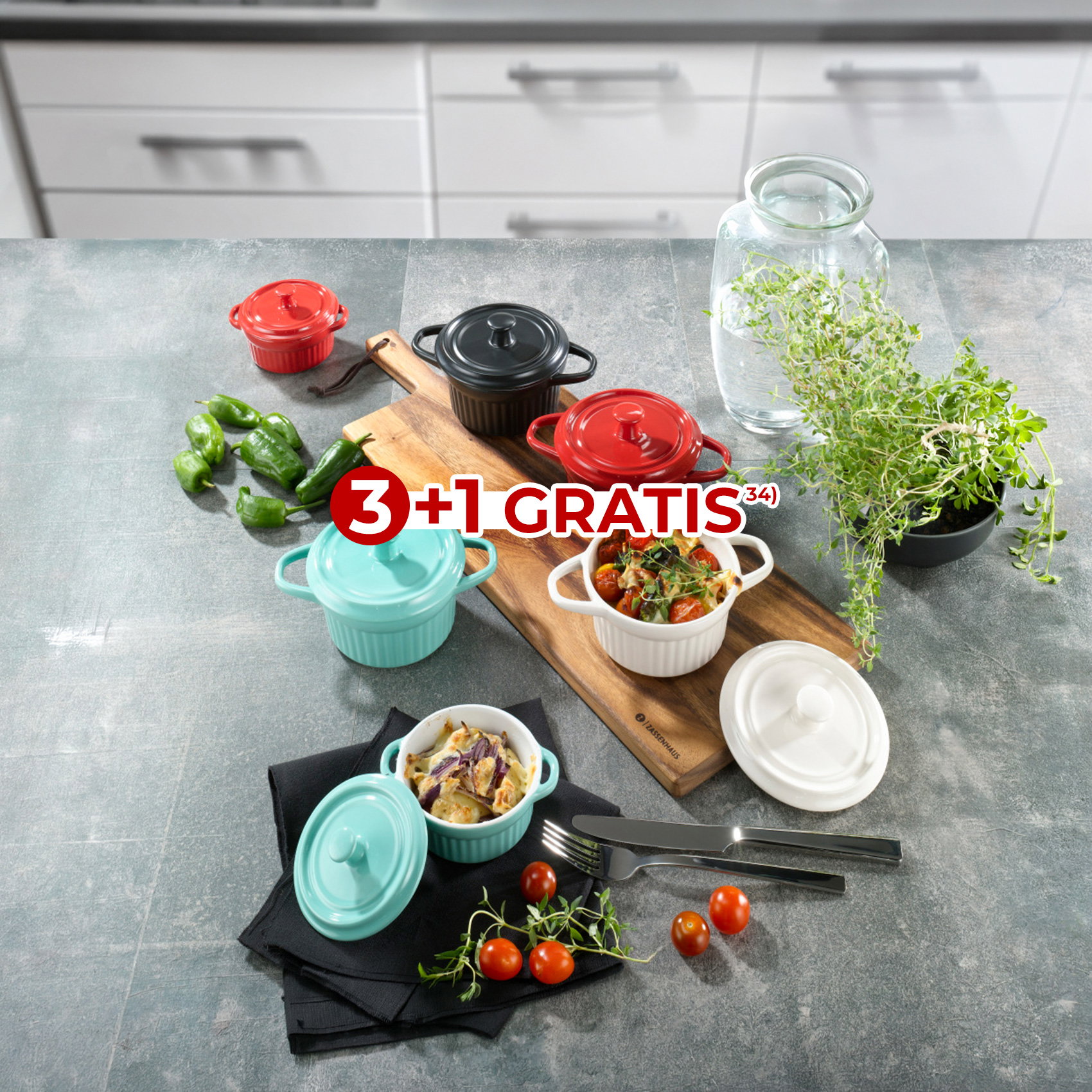 Mini-Cocottes in verschiedenen Farben mit Speisen auf Küchentheke, Aktion 3+1 gratis.