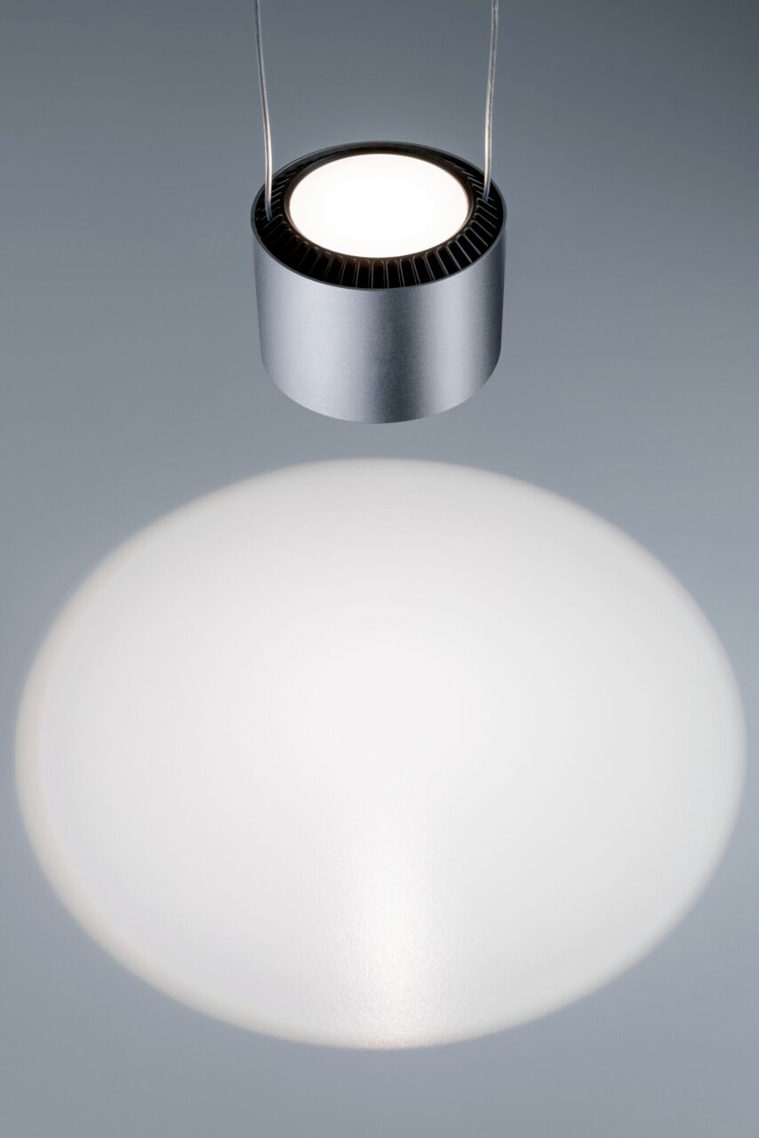 Moderne, zylindrische Hängeleuchte in silberner Optik, von oben betrachtet, mit hellem Lichtkegel auf der Oberfläche.