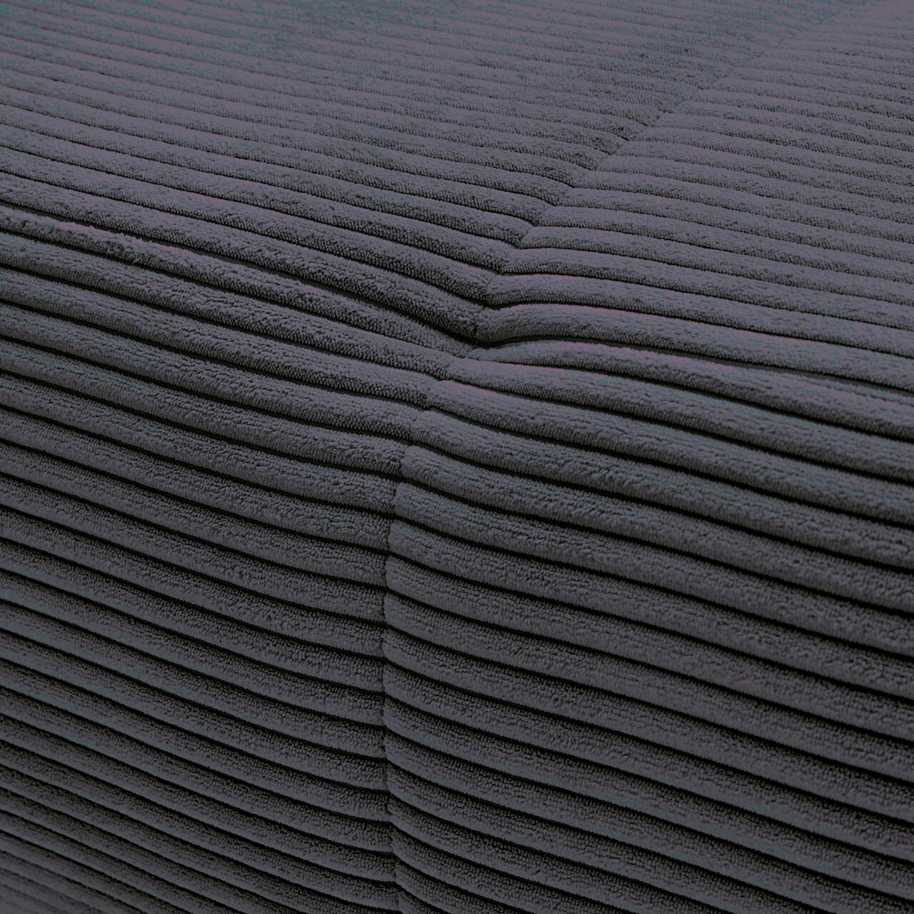 Nahaufnahme einer dunkelgrauen, gerippten Stoffoberfläche einer Rundecke aus der Perspektive einer Ecke.