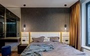 Moderne Hängeleuchte aus schwarzem Metall über einem Bett, seitliche Perspektive