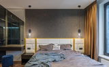 Moderne Hängeleuchte aus schwarzem Metall über einem Bett, seitliche Perspektive