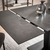 Moderner Esstisch mit dunkler, erweiterbarer Tischplatte aus der Vogelperspektive.