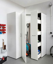 Mehrzweckschrank in einer Garage, teilweise geöffnet, mit Blick auf Regale und gelagerte Gegenstände.