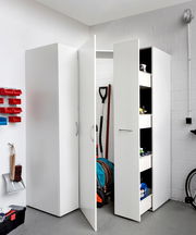 Mehrzweckschrank in einer Garage, teilweise geöffnet, mit Blick auf Regale und gelagerte Gegenstände.