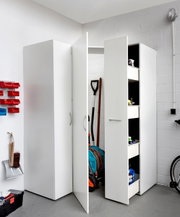 Multifunctionele kast in een garage, gedeeltelijk open, met zicht op de planken en de opgeslagen spullen.