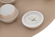Close-up van een led-plafondlamp met meerdere ronde lichtelementen in beige, gezien van bovenaf.