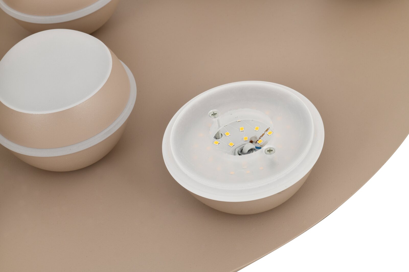 Close-up van een led-plafondlamp met meerdere ronde lichtelementen in beige, gezien van bovenaf.