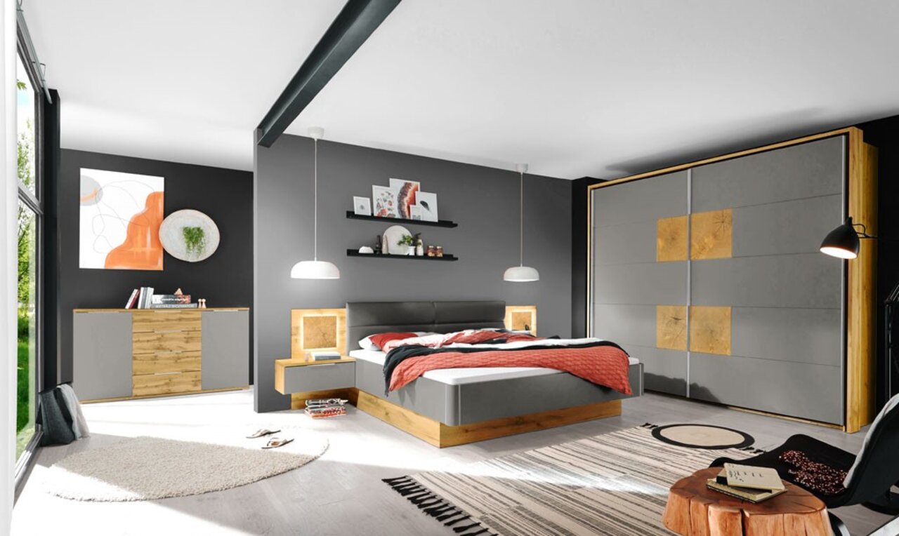 Moderne Schlafzimmeransicht mit grauem und holzfarbenem Bett, passendem Kleiderschrank und Nachttischen, aus der Perspektive von links vorne.