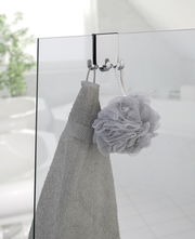 Edelstahl Doppel-Duschhaken an einer Glastür, von vorne betrachtet, mit einem Handtuch und einem Duschschwamm aufgehängt.