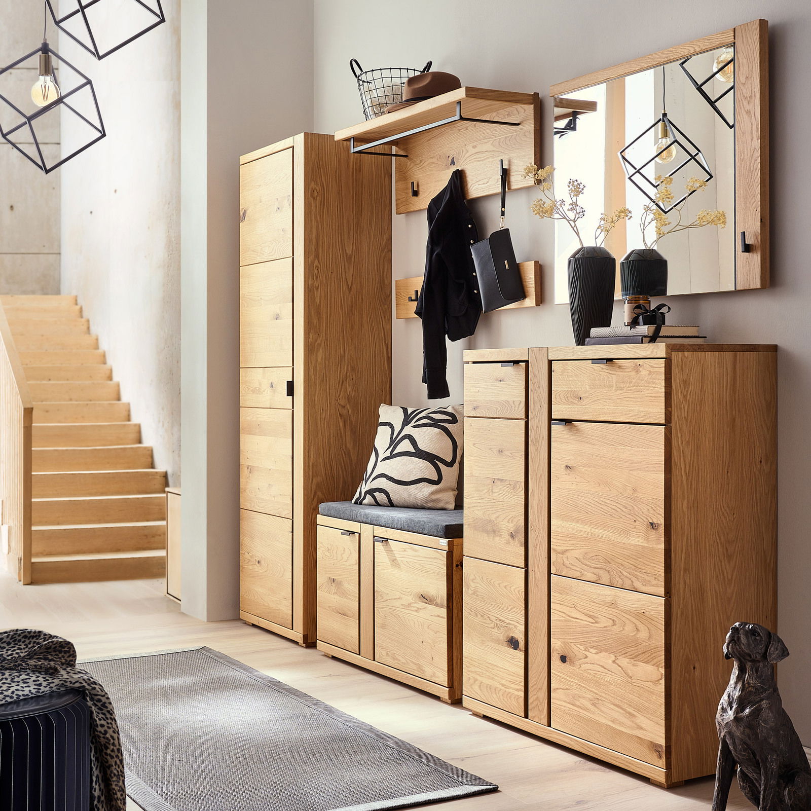 Moderne Garderobenkombination aus Holz mit Sitzbank, Garderobenpaneel, Hakenleiste, Schuhkommode und Spiegel in einer einladenden Flurperspektive.