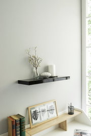 Schwarzes Wandboard mit Dekoration, seitliche Perspektive