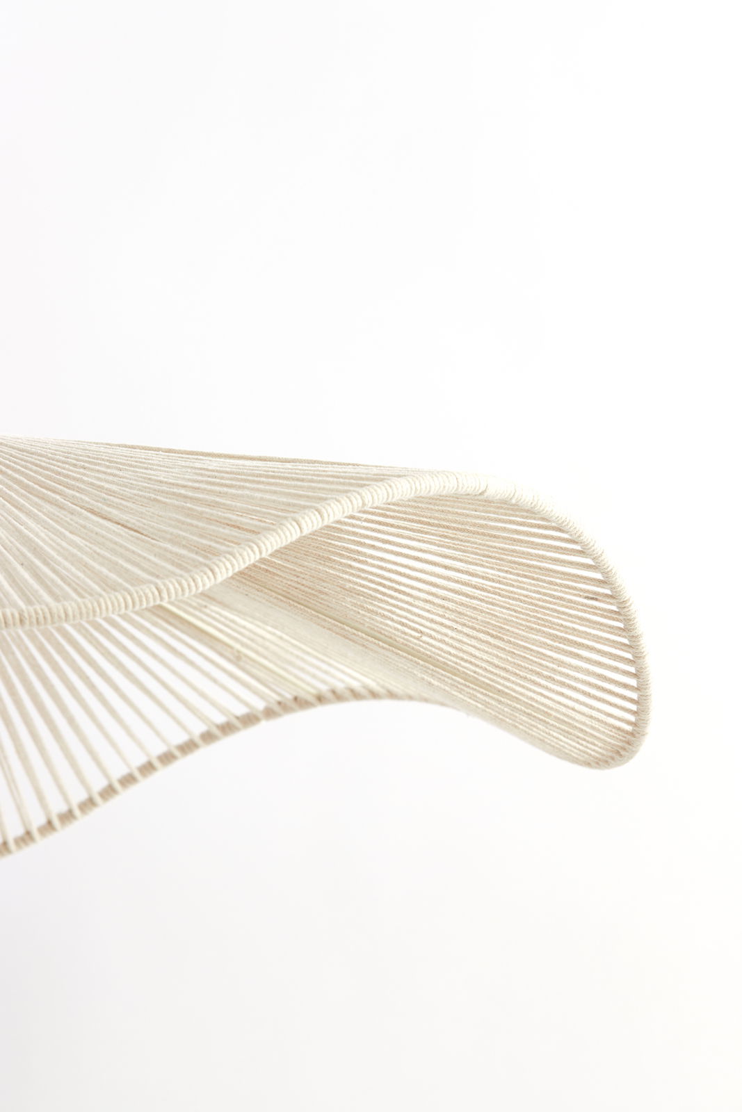 Nahaufnahme einer Hängeleuchte mit geschwungenem, faserigem Design aus seitlicher Perspektive.