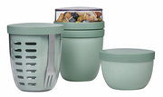 Dreiteiliges Snackpot-Set in Salbeigrün, bestehend aus einem großen Behälter mit Gabel, einem mittleren Behälter mit transparentem Deckel gefüllt mit Nüssen und einem kleinen Behälter, seitliche Perspektive.