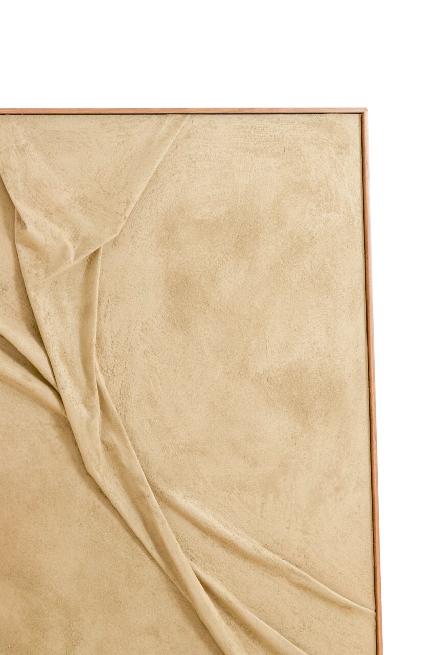 Nahaufnahme eines Wandornaments mit beigem Stoff, der in Falten gelegt ist, in einem Holzrahmen.