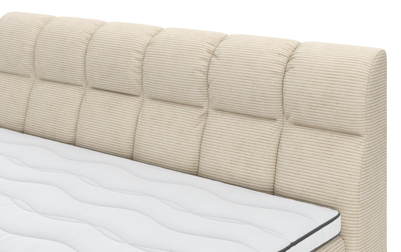Close-up van een boxspringbed met een doorgestikt, beige gestreept hoofdeinde en een wit matras, gezien vanaf de zijkant