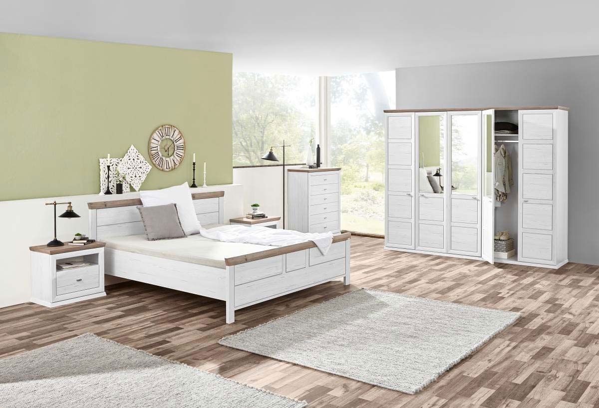Schlafzimmer mit einem weißen Bett 140x200 cm, flankiert von zwei Nachttischen, in einem hellen Raum mit großen Fenstern, aus der Perspektive von vorne links.