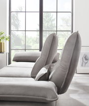 Graue Longchairkombination von W. Schillig, Modell 16777 BROADWAY, seitliche Perspektive mit verstellbaren Rückenlehnen vor einem großen Fenster.