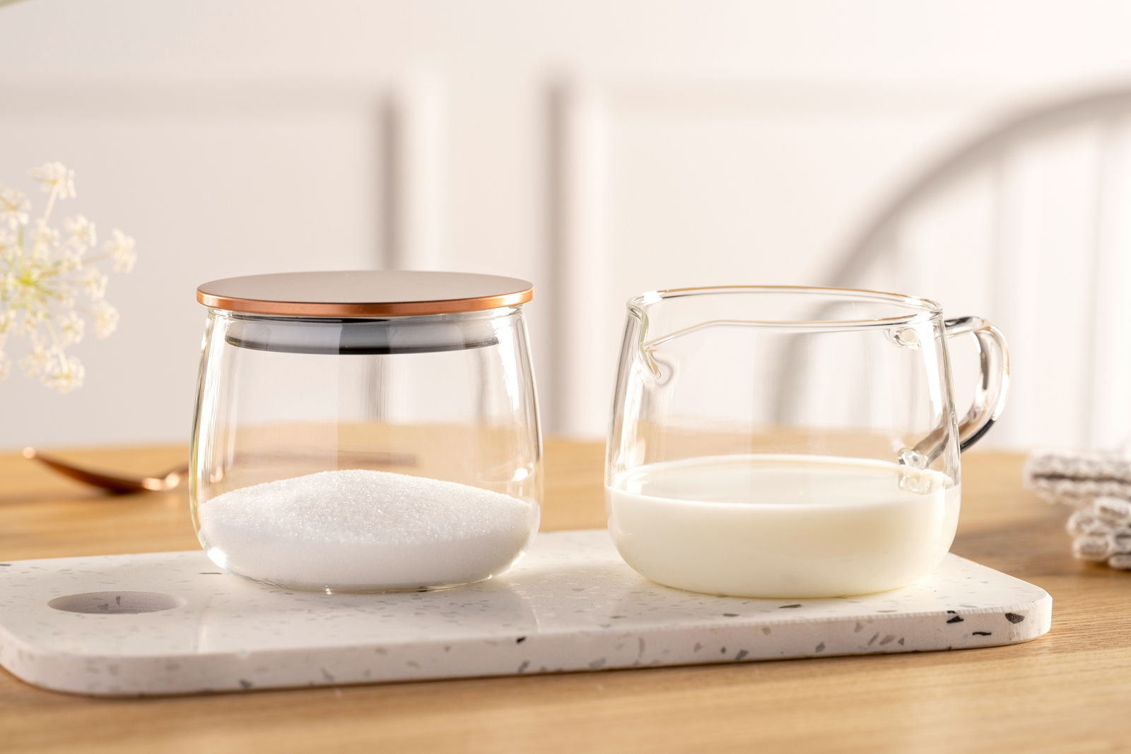 Milchkännchen TE PER TE 350ml aus Glas, gefüllt mit Milch, auf einer hellen Küchenarbeitsplatte, seitliche Perspektive.