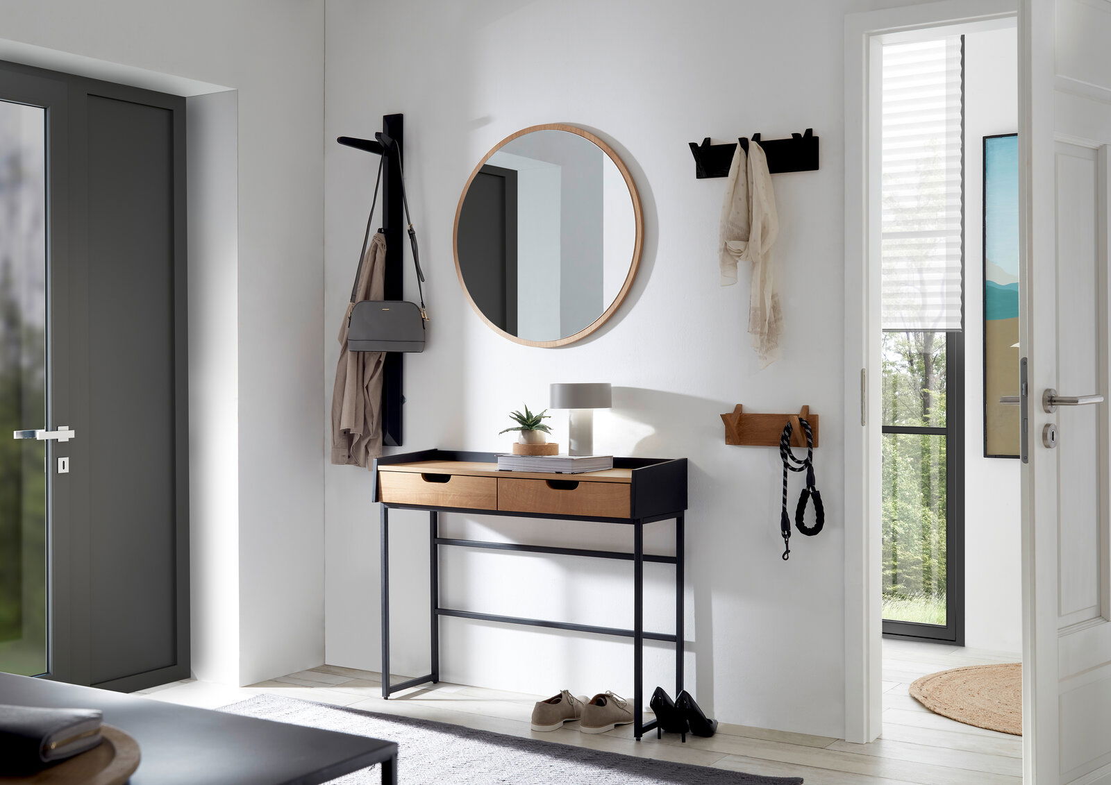 Linea Natura Garderobenpaneel BANTRY Moderner Eingangsbereich mit runder Spiegel, Konsole mit zwei Schubladen und Hakenleisten an der Wand, seitliche Perspektive.