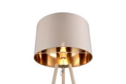 Beige Tripod-Stehlampe mit zylindrischem Stoffschirm und goldfarbener Innenseite, eingeschaltet, Nahaufnahme aus leichtem Untersichtwinkel vor weißem Hintergrund