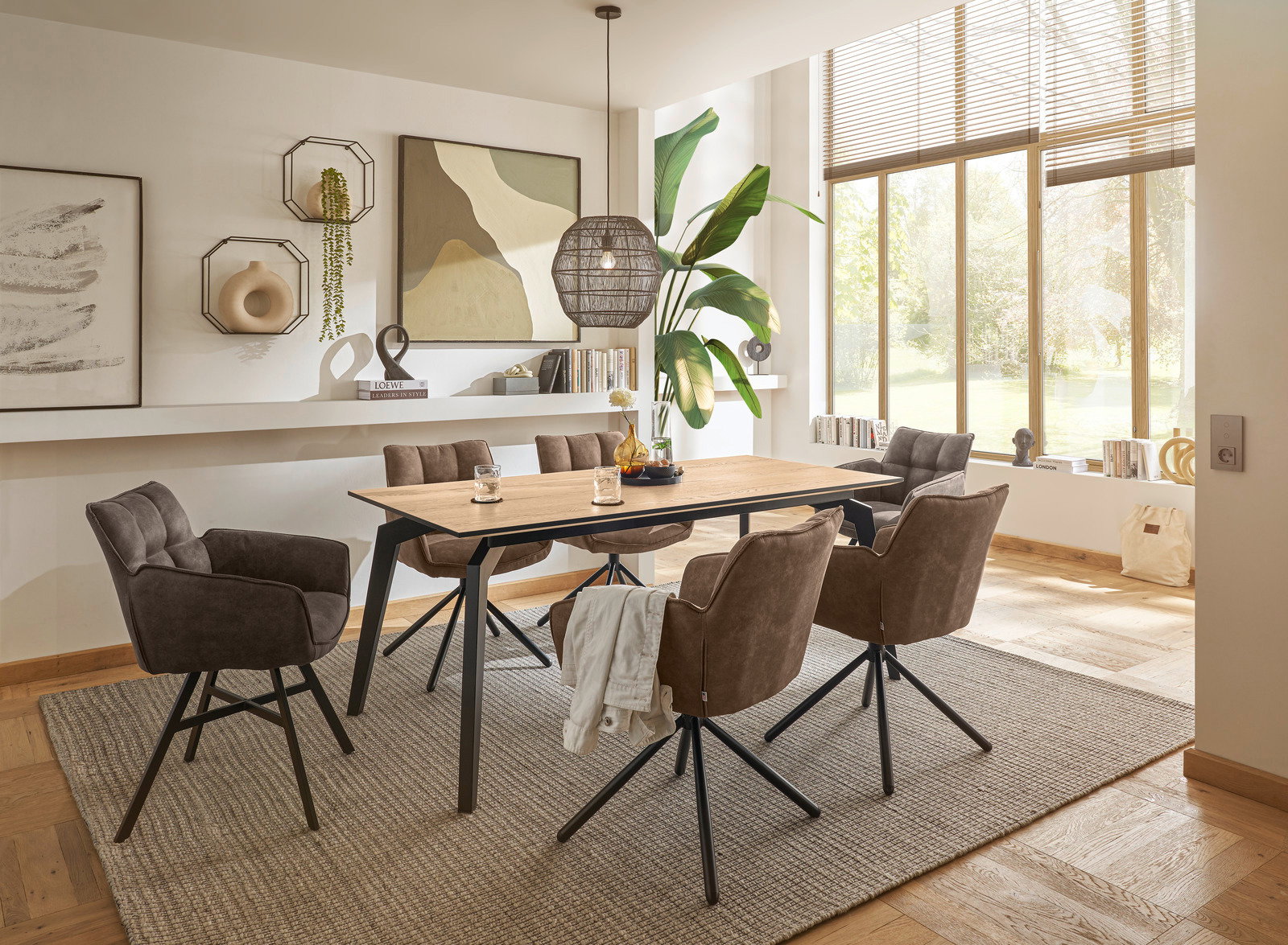 Moderner Esstisch 160x90 cm mit Holzplatte und schwarzen Metallbeinen, umgeben von gepolsterten Stühlen in einem hellen, stilvoll eingerichteten Raum mit großen Fenstern. Perspektive: seitlich.