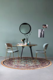 Runder Teppich mit orientalischem Muster in einem modernen Esszimmer, aus der Vogelperspektive fotografiert.