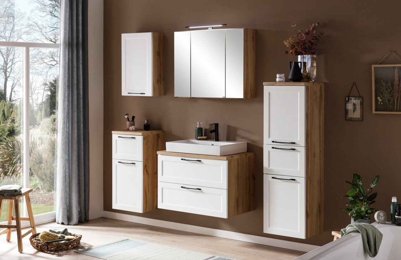 Modernes Waschtisch-Set in Holzoptik mit weißen Fronten, bestehend aus einem Waschbecken mit Unterschrank, einem Spiegelschrank und zusätzlichen Hängeschränken, seitliche Perspektive.