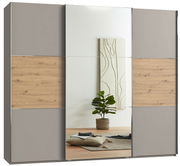 Moderner dreitüriger Schwebetürenschrank mit Spiegel in Holz- und Grautönen, frontal abgebildet. Der Schrank hat eine mittlere Spiegeltür und seitliche Paneele in Holzoptik und Grau.