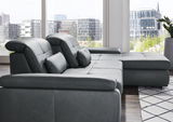 Moderne Longchairkombination in dunklem Leder, seitliche Perspektive mit Blick auf große Fenster und städtische Umgebung.