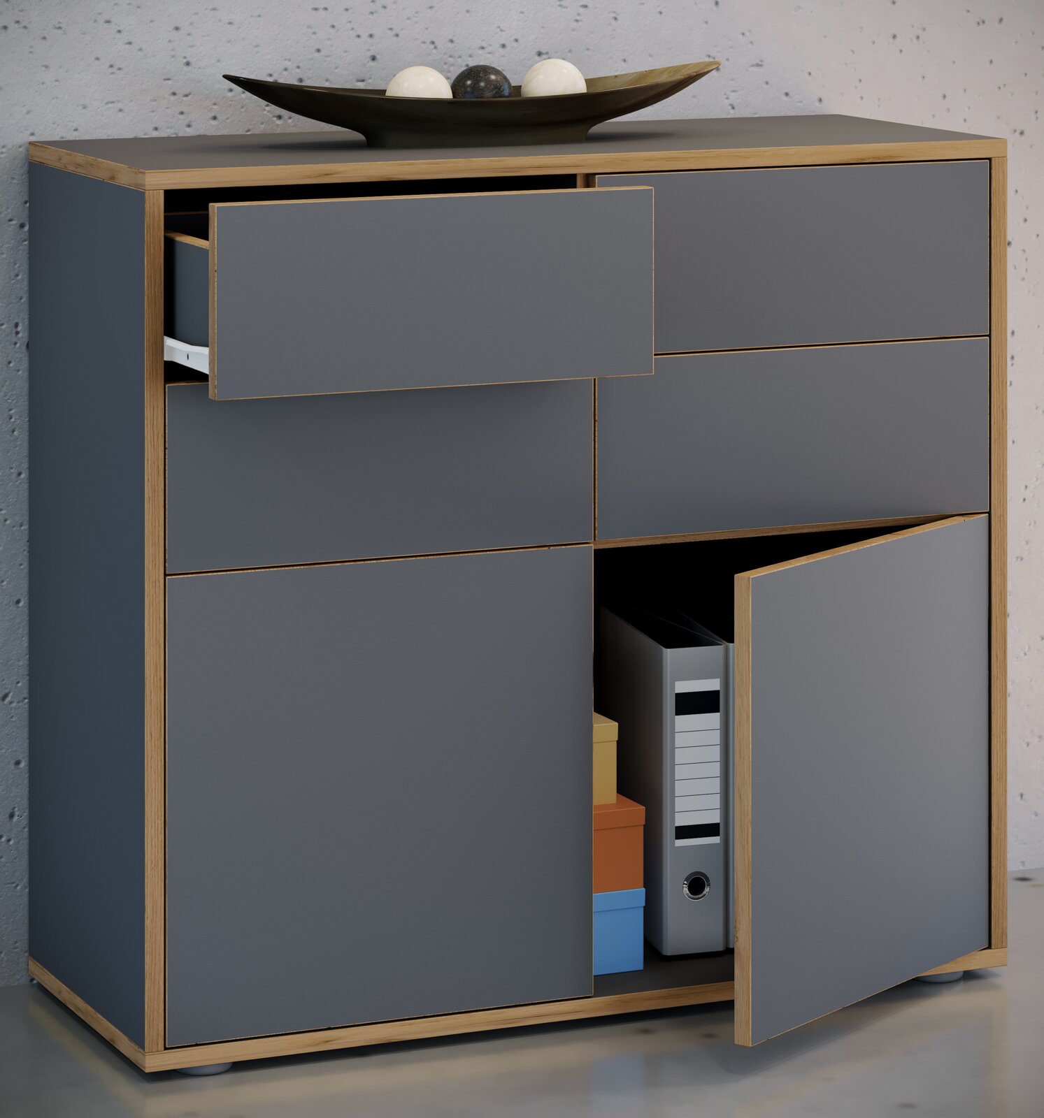 Modernes Sideboard in Anthrazit mit Holzrahmen, teils geöffneten Türen und Schublade, Blick leicht von vorne/seitlich oben dekorative Schale mit Kugeln