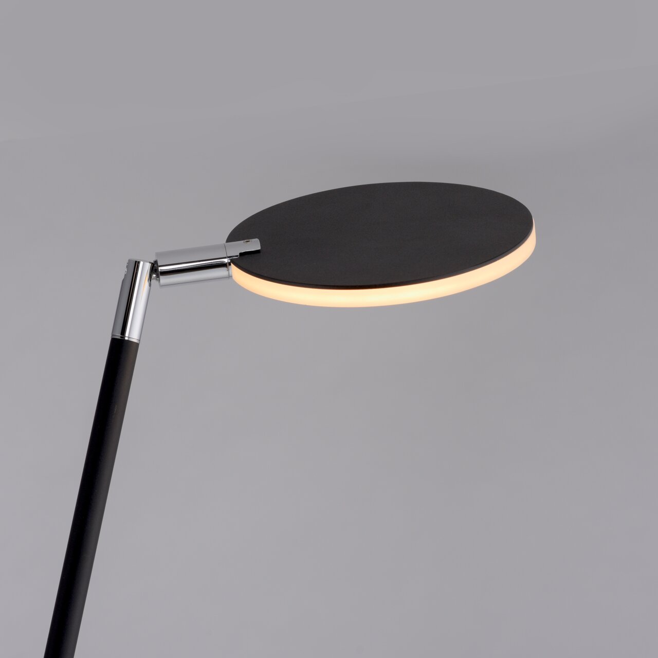 Moderne Akku-Stehleuchte mit rundem, flachem Leuchtkopf in seitlicher Perspektive.