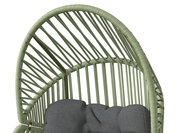 Nahaufnahme eines Gartensessels mit grünem Rattangeflecht und grauem Kissen, von oben betrachtet.