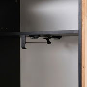 Innenansicht eines Garderobenschranks mit schwarzem Regalboden und Kleiderstange, seitliche Perspektive