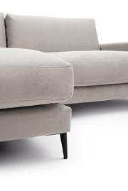 Nahaufnahme einer modernen, hellgrauen Longchairkombination mit eleganten schwarzen Beinen, seitliche Perspektive.