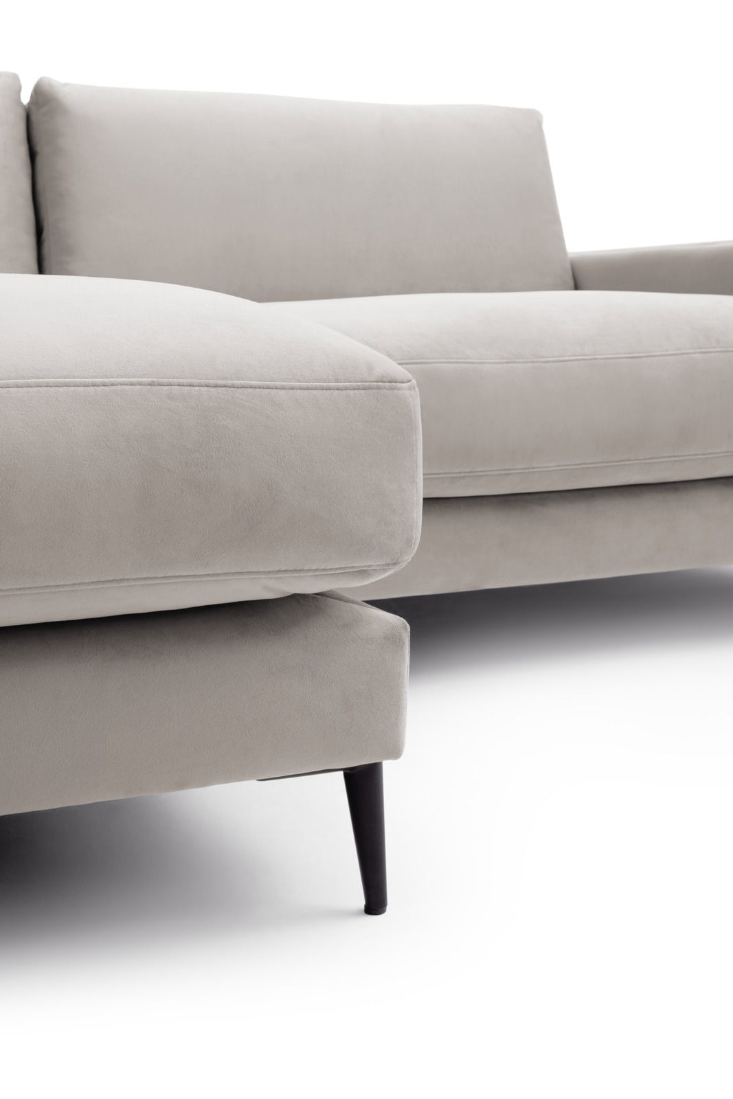 Nahaufnahme einer modernen, hellgrauen Longchairkombination mit eleganten schwarzen Beinen, seitliche Perspektive.