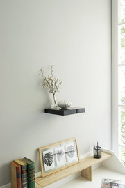 Schwarzes Wandboard mit Vase und Dekoration, seitliche Perspektive