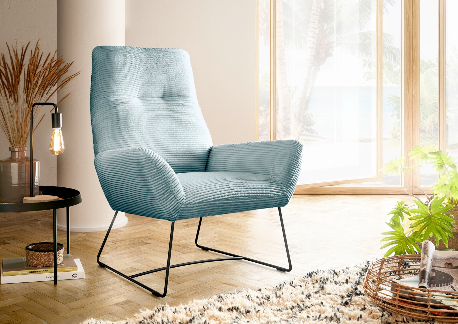 Lounge Handmade Sessel LH-BEN Moderner blauer Sessel mit geripptem Stoffbezug, seitliche Perspektive, in einem hellen Raum mit großen Fenstern und Holzboden.