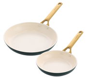 Zwei Bratpfannen in verschiedenen Größen mit cremefarbener Innenbeschichtung und goldenen Griffen, aus der Vogelperspektive fotografiert.