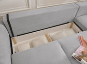 Graues Sofa mit Stauraum, geöffnet, mit Kissen und Decken, aus der Vogelperspektive.