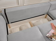 Graues Sofa mit Stauraum, geöffnet, mit Kissen und Decken, aus der Vogelperspektive.