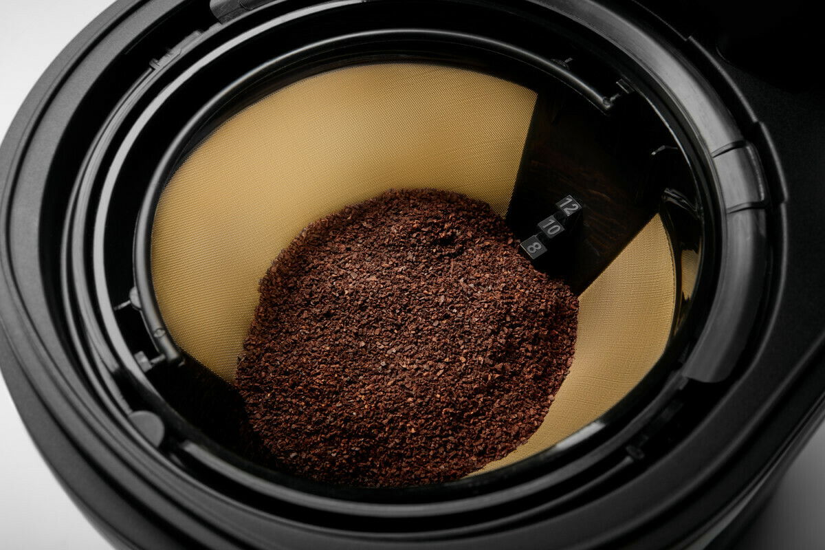 Nahaufnahme eines Kaffeefilters mit gemahlenem Kaffee in einer Kaffeemaschine, von oben betrachtet.