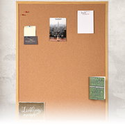 Kork-Pinnwand mit Holzrahmen, dekoriert mit verschiedenen Notizen und Karten, frontal fotografiert.