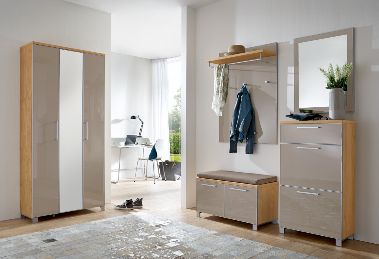 VOSS Schuhschrank schmal SANTINA Moderne Garderobeneinrichtung mit Dielenschrank, Garderobenpaneel, Sitzbank und Spiegel in heller Holzoptik und Hochglanzfronten, seitliche Perspektive.