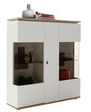 Weißes Highboard mit Glastüren und Holzdetails, dekoriert mit Vasen und Büchern, seitliche Perspektive