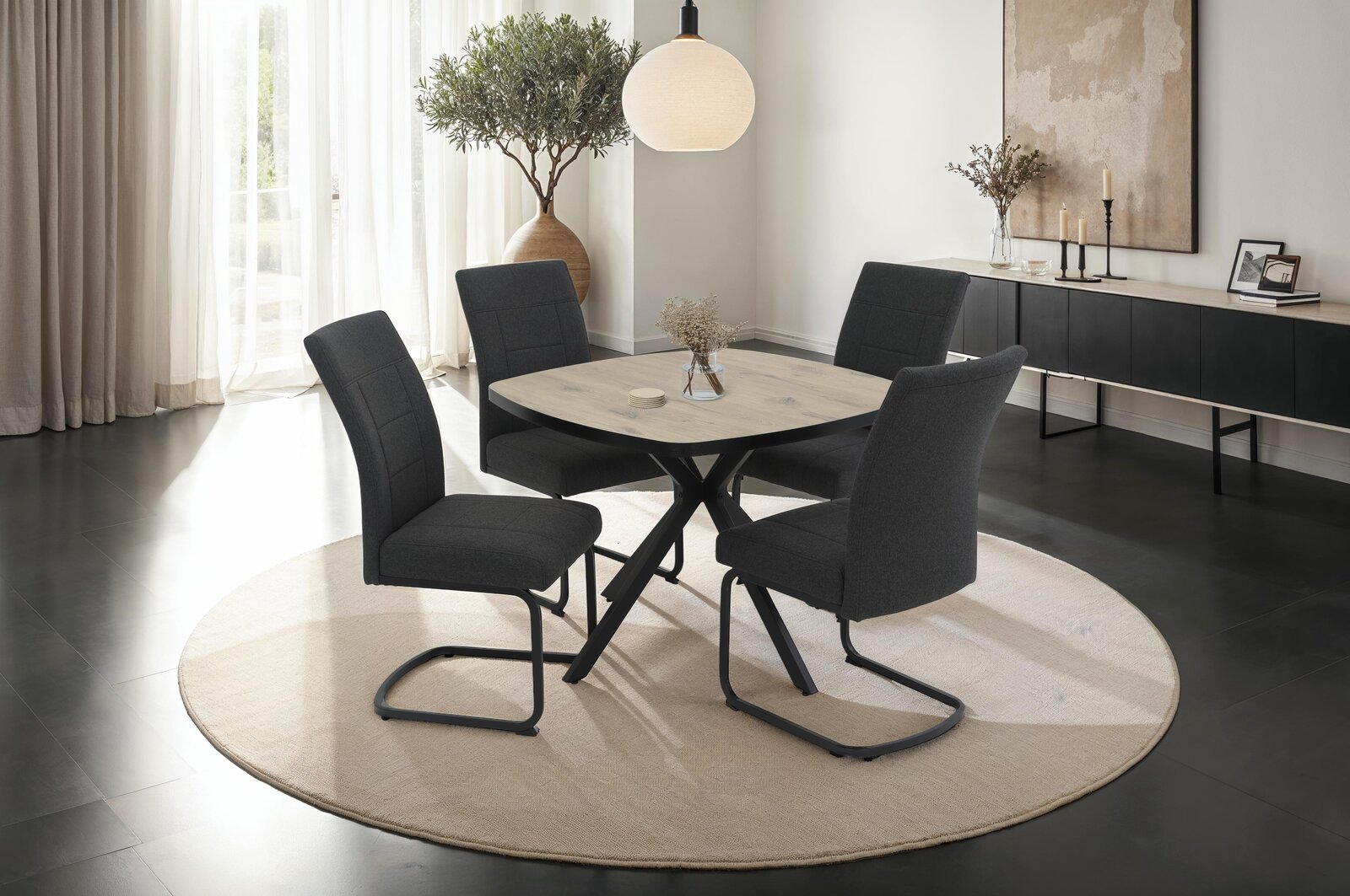 Moderner Essbereich mit vier Schwingstühlen um einen runden Tisch, seitliche Perspektive.