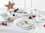 Festlich gedeckter Tisch mit weißem Porzellan-Geschirrset (Teller, Schalen, Tassen), goldfarbenem Besteck und Weihnachtsdeko in Rot/Silber, aufgenommen in leicht schräger Seitenansicht von oben.