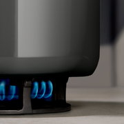 Nahaufnahme eines Topfes auf einem Gasherd mit blauer Flamme.