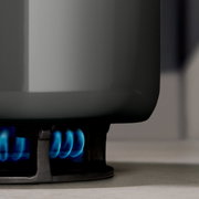 Nahaufnahme eines Topfes auf einem Gasherd mit blauer Flamme.