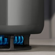 Nahaufnahme eines Topfes auf einem Gasherd mit blauer Flamme.